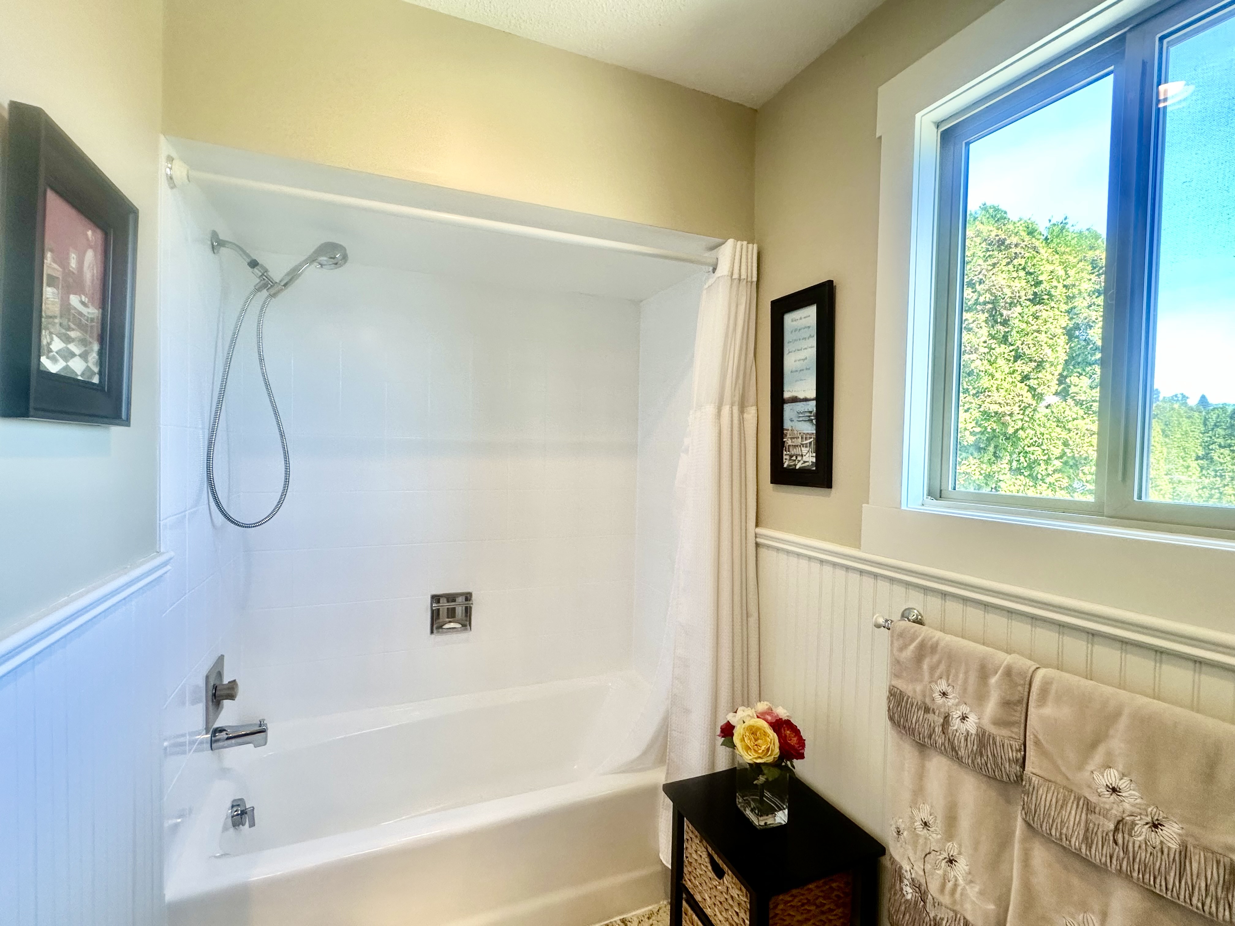 Main bathroom with soaker tub, shower, beadboard wainscoting and garden window